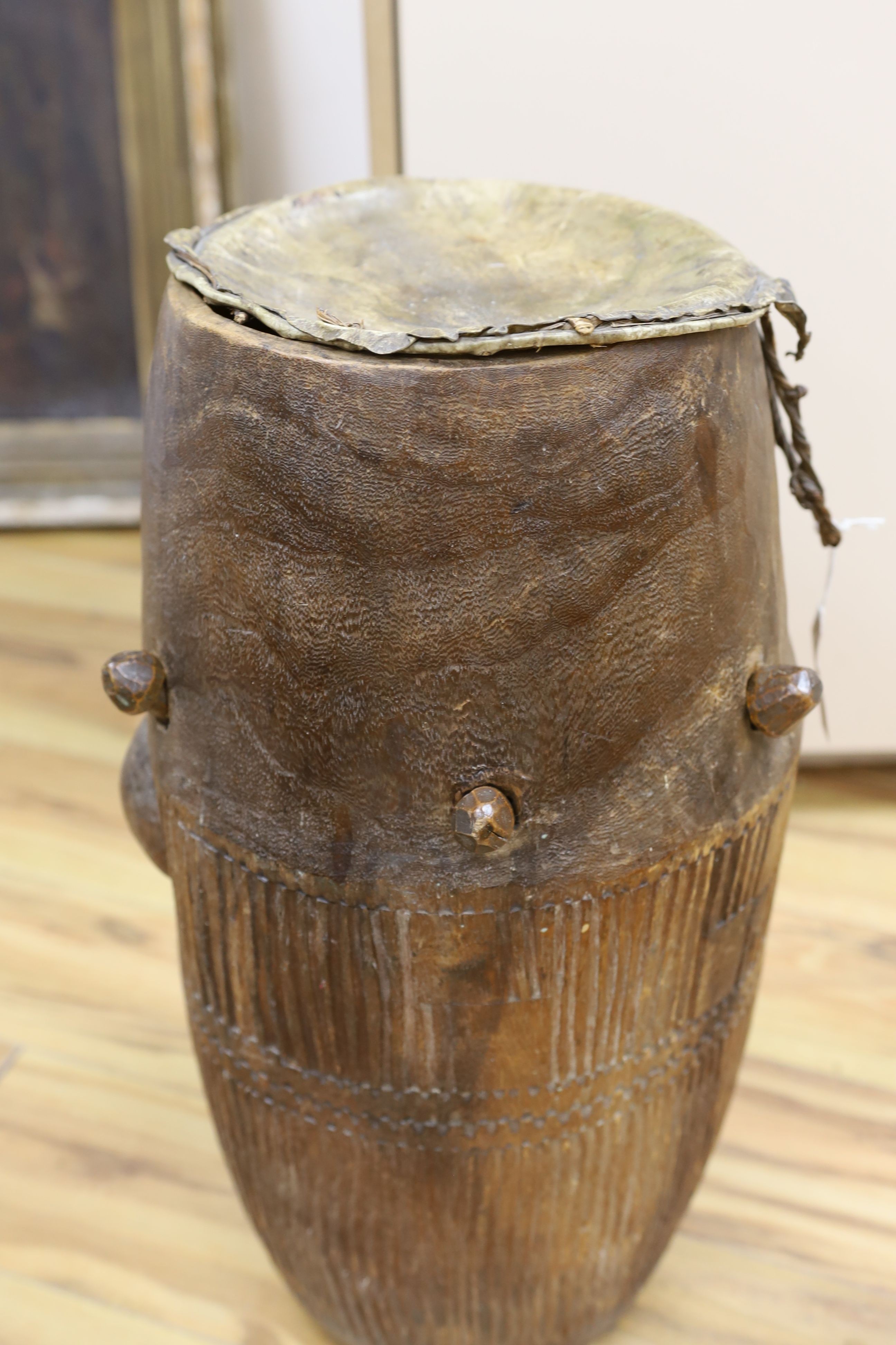 A 19th/20th century Ashanti breasted drum, 61 cms high.